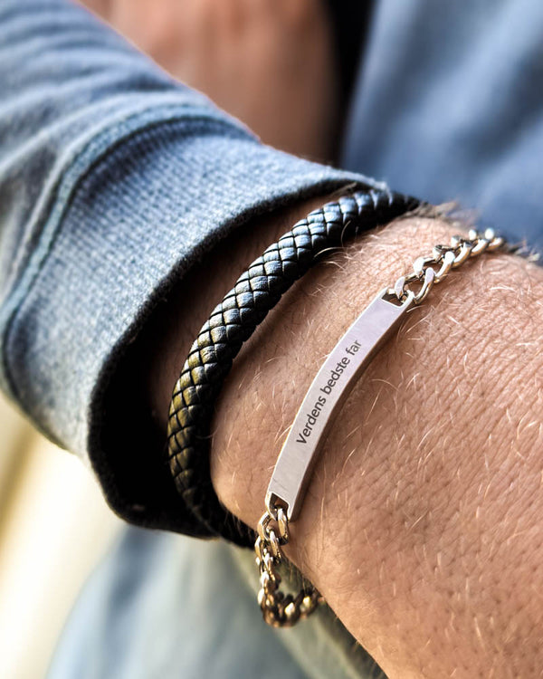 ARA bracelet in silver-coloured stainless steel with the engraving "Verdens bedste far" on the wrist, worn with RAY braided leather bracelet