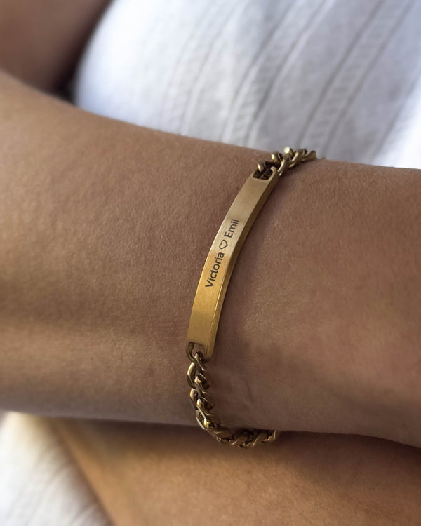 AVA bracelet in brushed gold-plated stainless steel with personalised engraving "Victoria ♡ Emil" worn on the wrist