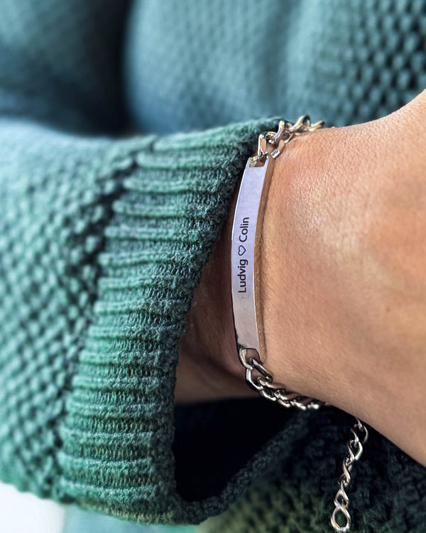 AVA name bracelet in silver-coloured stainless steel with the engraving "Ludvig ♡ Colin" on the wrist, green knit
