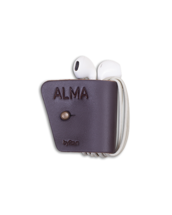 KAX earbud clip from byRavn in dark brown leather with earbuds wrapped around and the engraving "Alma"