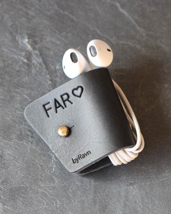 KAX leather earbud holder in black with personalised engraving "Far" ♡ and brass stud, with earpods on dark slate