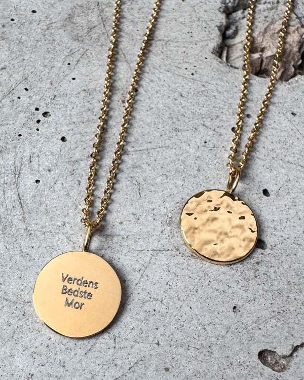 MOON QUOTE necklace in gold-plated stainless steel with "Verdens Bedste Mor" engraved on round coin, hammered back alongside, on concrete