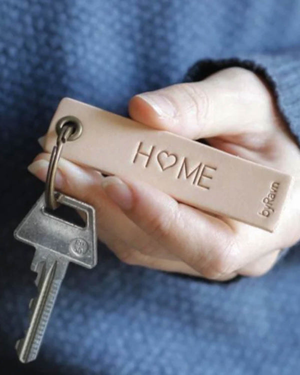 SOLO Small keyring in natural leather held in hand with key and the engraving "Home" with a heart as the O