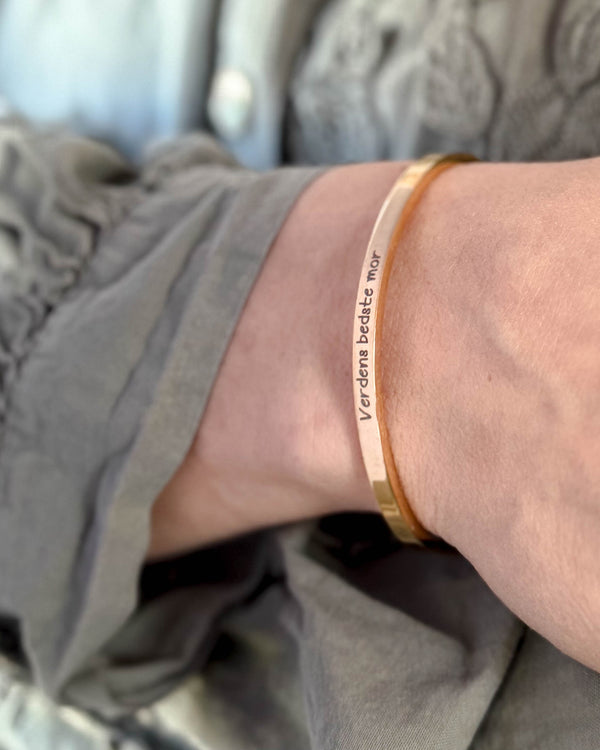 VENUS SCRIPT bracelet in gold-plated stainless steel with "Verdens bedste mor" in script on the wrist, grey blouse