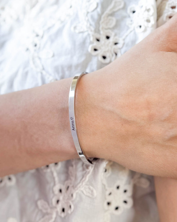 VENUS SCRIPT bracelet in silver-coloured stainless steel with the name "Anna" ♡ in script on the wrist, white embroidered blouse