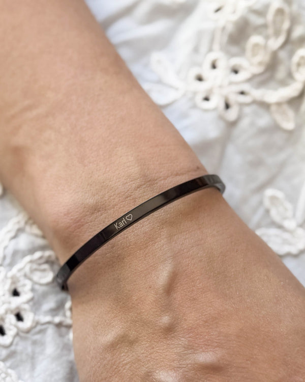 VENUS bracelet in black stainless steel with the name "Karl" ♡ engraved on the wrist, white embroidered blouse