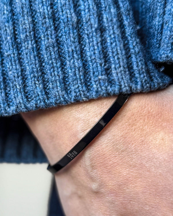 VENUS STICK bracelet in black stainless steel with engraved matchstick family on the wrist, blue ribbed knit