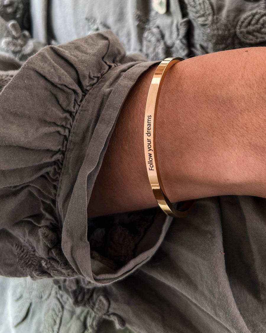 VENUS bracelet in gold-plated stainless steel with the engraving "Follow your dreams" worn on the wrist
