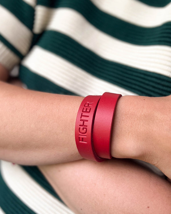 DUO leather bracelet in red with the engraving "Fighter" wrapped twice around the wrist, green and white striped top