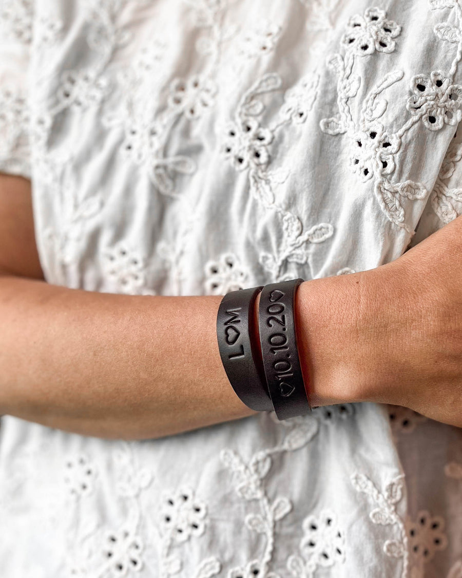 DUO leather bracelet in dark brown with the engravings "L ♡ M" and "♡ 10.10.20 ♡" on the wrist, white embroidered blouse