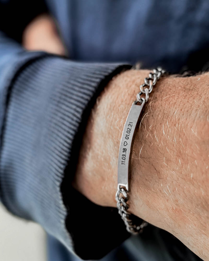 ARA bracelet in silver-coloured stainless steel with the dates "11.03.18 ♡ 01.02.21" engraved, on a man's wrist, blue sweatshirt