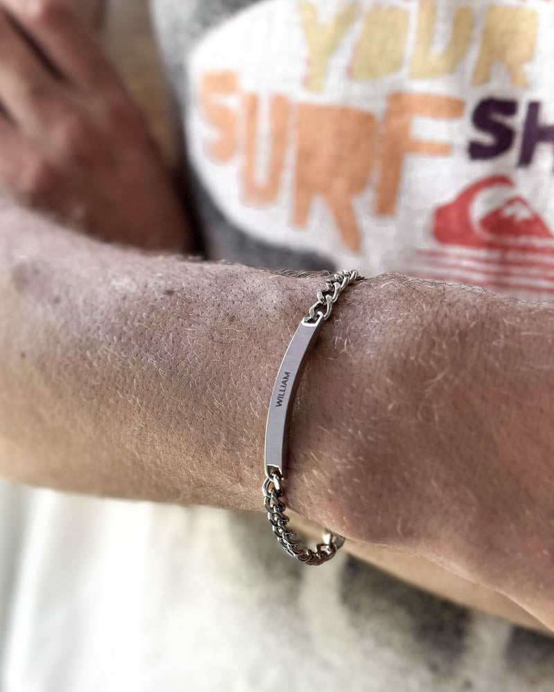 ARA name bracelet in silver-coloured stainless steel with the name "William" engraved, worn on the wrist at the beach