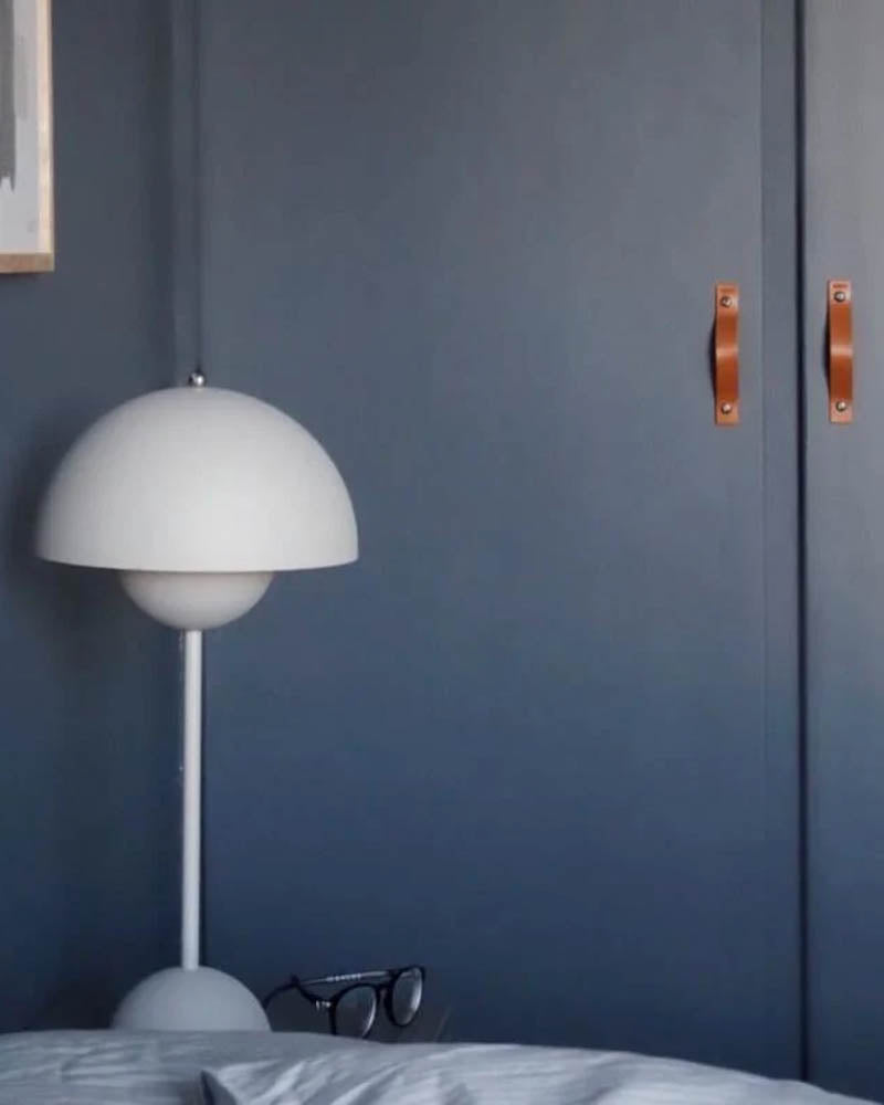 BAND leather handles in cognac on two navy blue wardrobe doors in a bedroom with white Flowerpot lamp