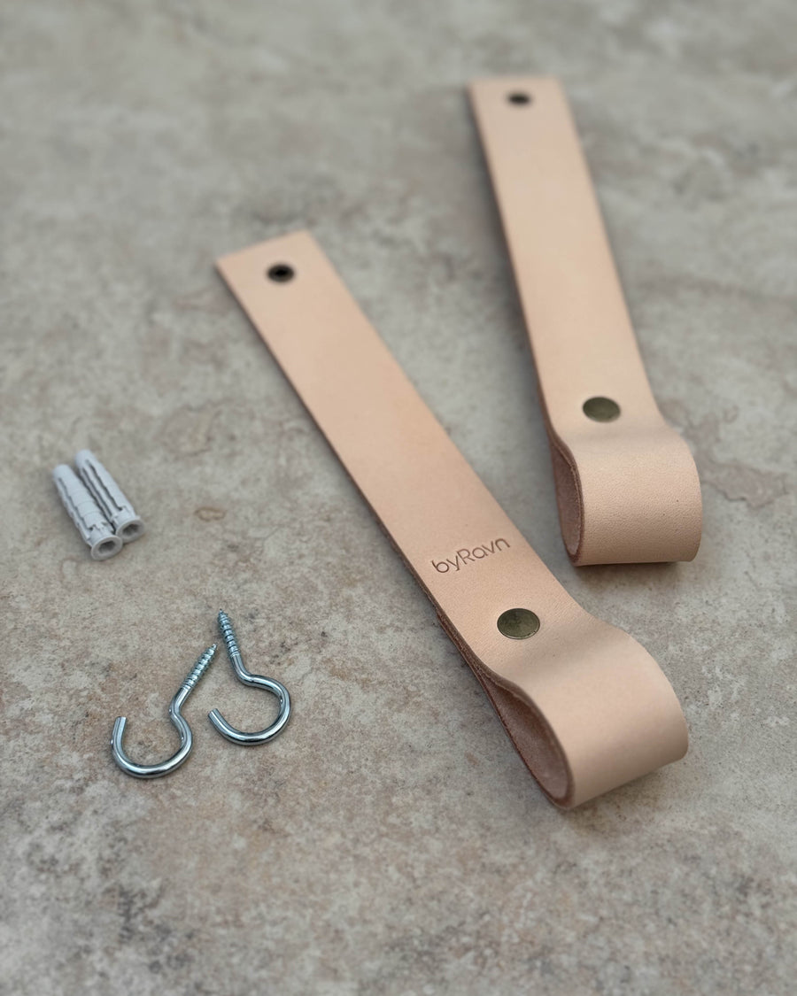 HOLD 15 leather hanging straps, shown here in natural, with byRavn embossing, screw hooks and wall plugs