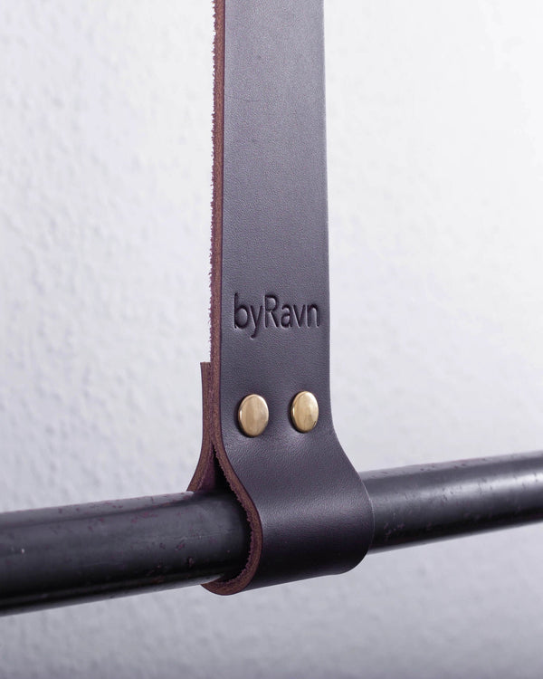 HOLD 30 hanging strap in dark brown full-grain leather with two brass rivets and byRavn embossing around a black metal rail