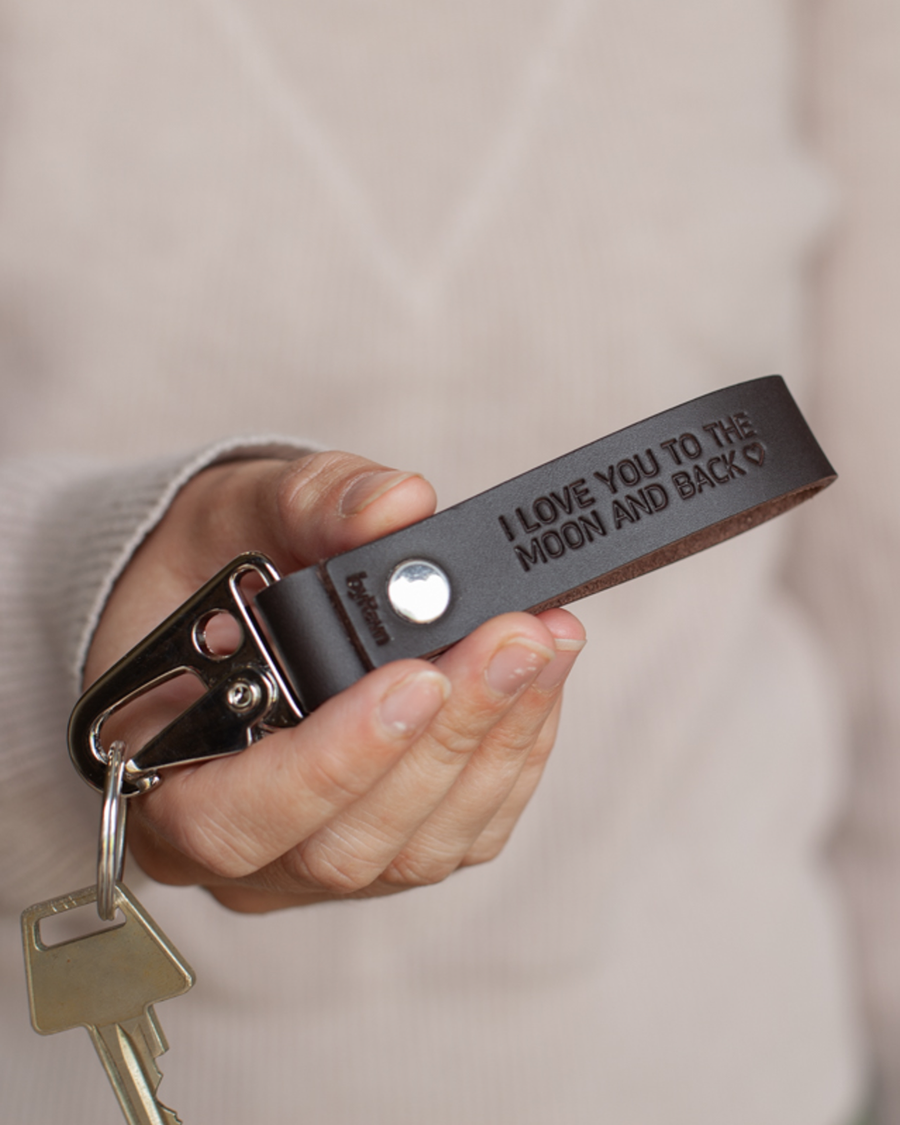 HOOK leather keyring in dark brown with steel carabiner and the engraving "I love you to the moon and back" ♡ held in hand