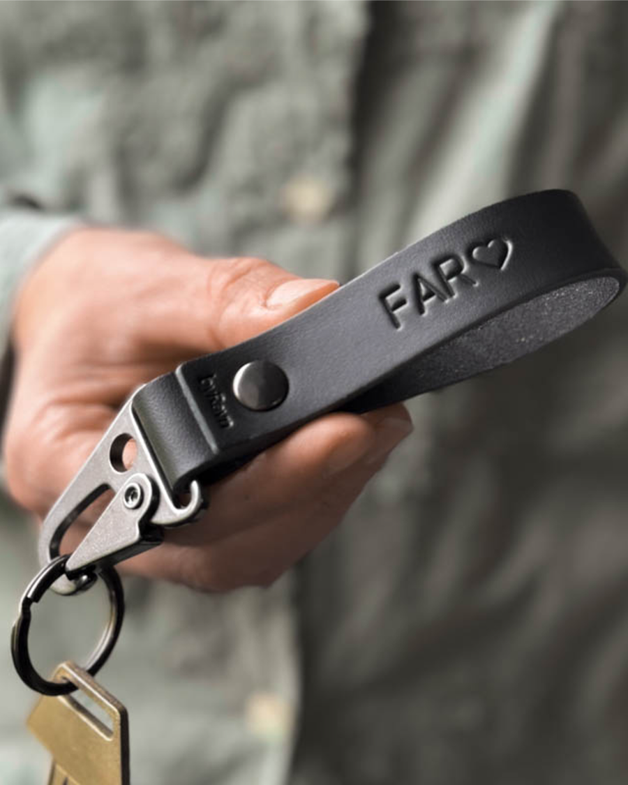 HOOK leather keyring in black with steel carabiner and the engraving "Far" ♡, held in hand with key