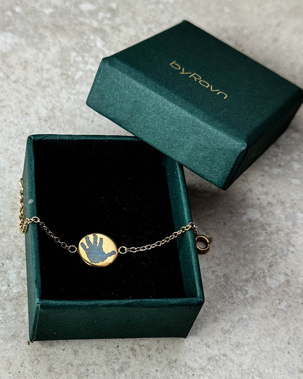 IBI MOTIF bracelet in gold-plated stainless steel with a child's handprint engraved, in a dark green byRavn jewellery box
