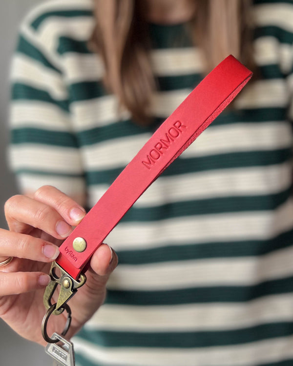 IRON leather keyring in red with long strap and the engraving "Mormor", held in hand with key