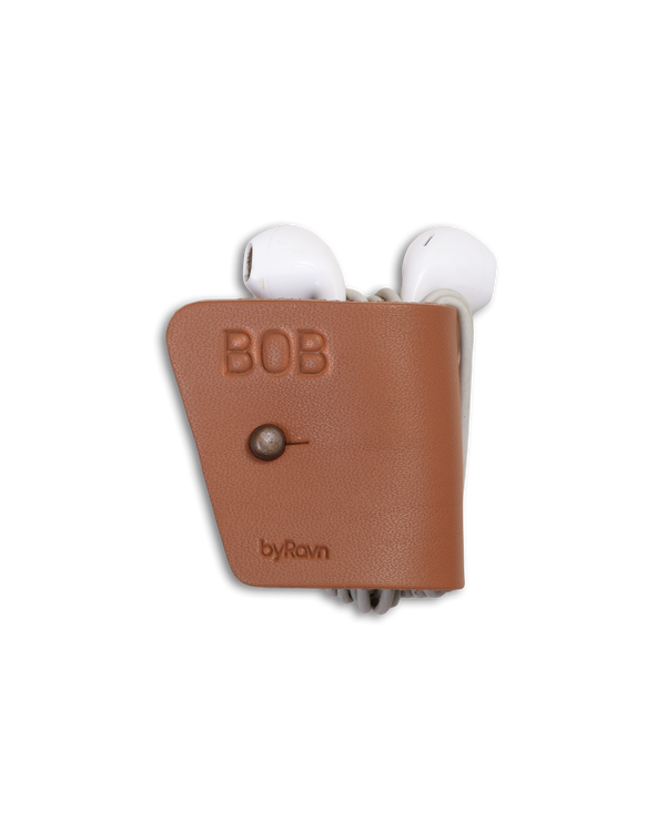 KAX leather earbud holder from byRavn in cognac with antique brass sam browne stud and the name "Bob" engraved, with earpods