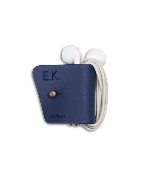 KAX earbud clip from byRavn in navy blue leather with white earbuds and the initials "E.K." engraved