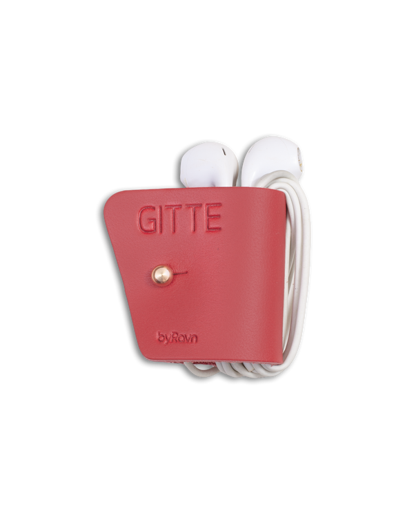 KAX earbud clip from byRavn in red leather with white earpods wrapped around and the name "Gitte" engraved