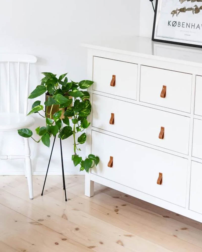 LOOP leather drawer pulls in cognac on a white six-drawer dresser in a bright living room with plant and Copenhagen poster