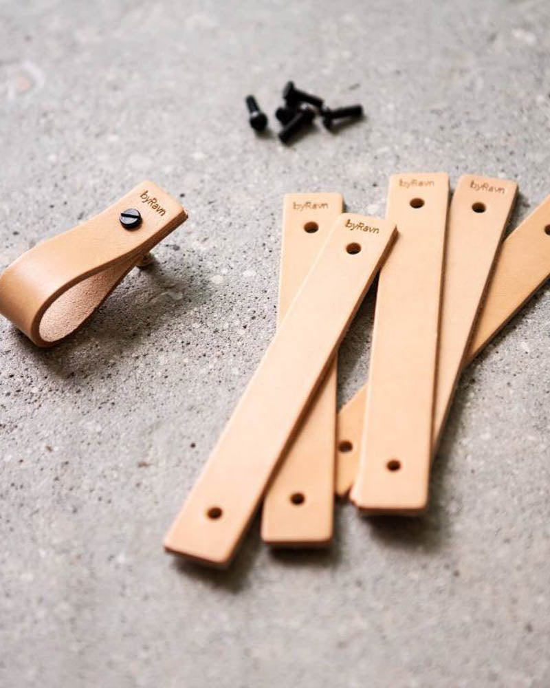 LOOP leather drawer pulls in natural, several leather strips with byRavn embossing, one assembled pull and black screws