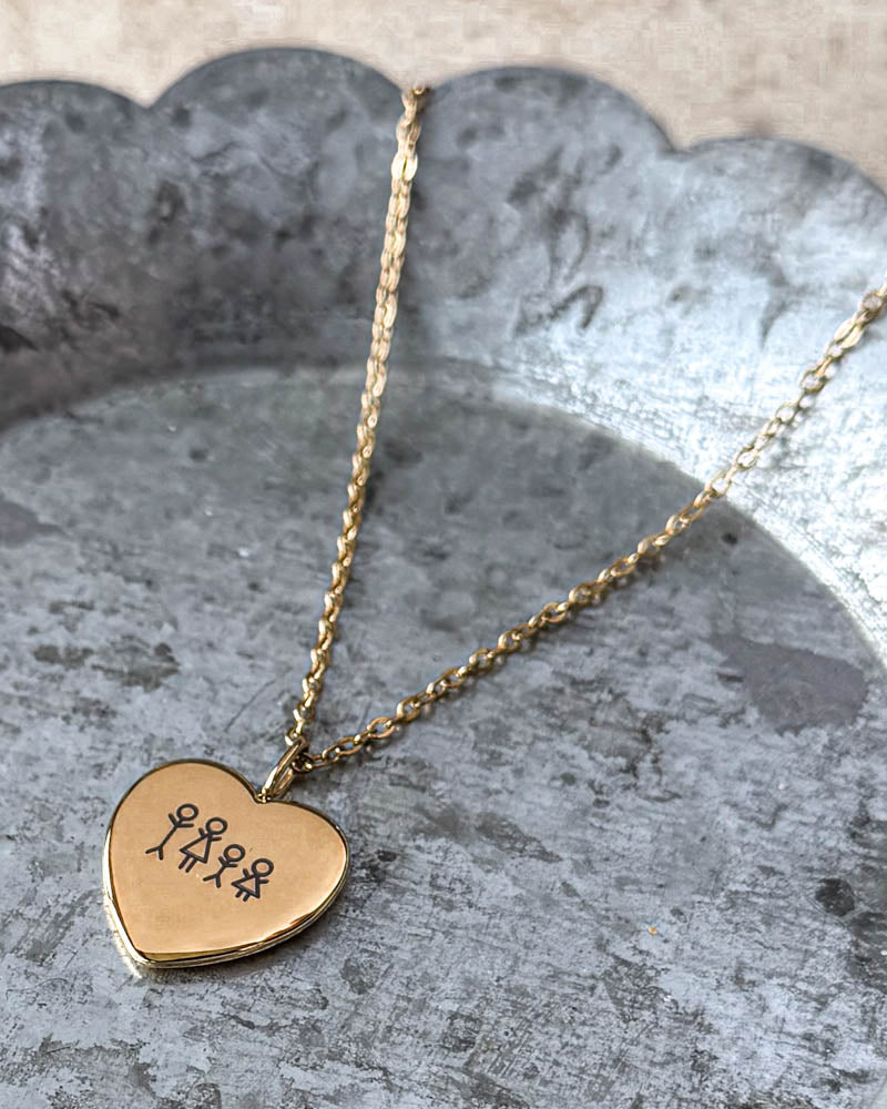 LUV STICK necklace in gold-plated stainless steel with a matchstick family of four engraved in heart pendant, on a wavy-edged zinc tray