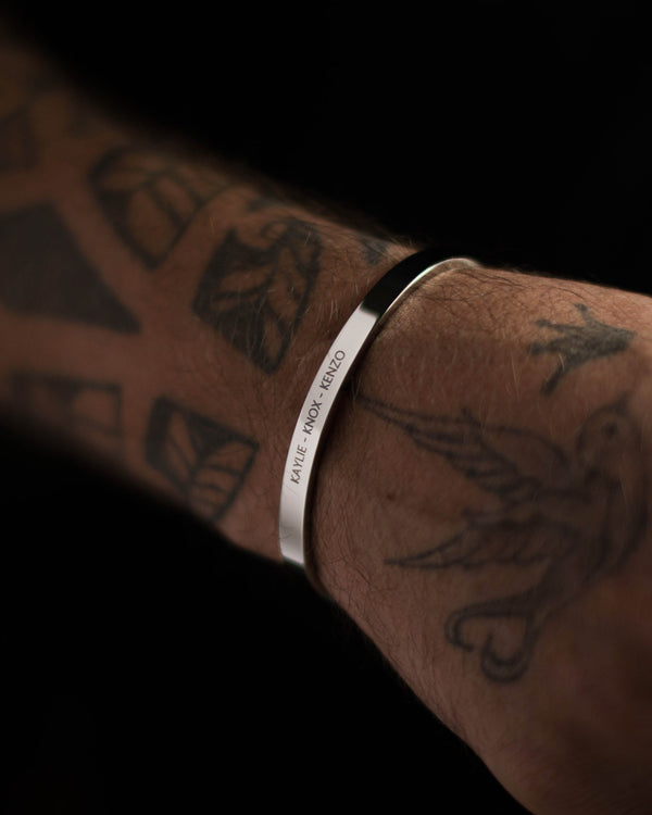 MARS bracelet in silver-coloured stainless steel with the engraving "Kaylie – Knox – Kenzo" on a tattooed man's arm