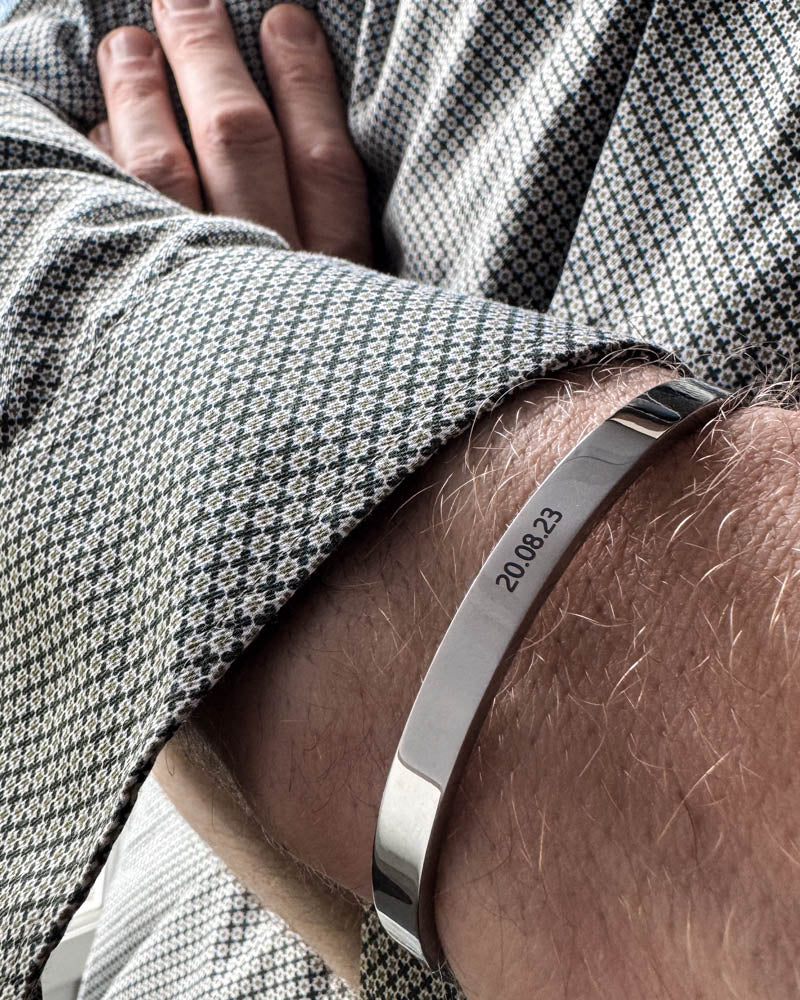 MARS bracelet in silver-coloured stainless steel with the date "20.08.23" engraved, worn with a patterned shirt