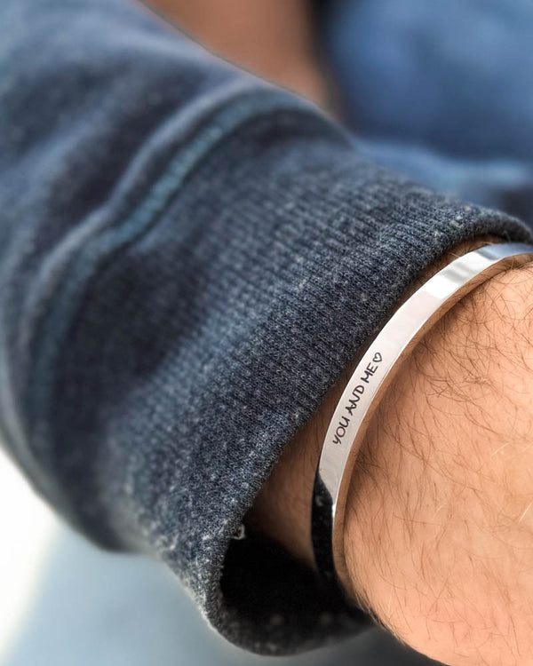 MARS SCRIPT bracelet in silver-coloured stainless steel with "You and me" ♡ engraved in handwriting, on the wrist, blue sweatshirt
