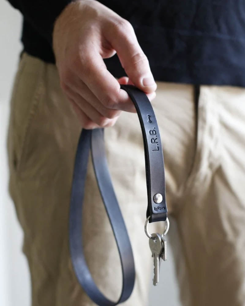 MAX leather keyring in black with the initials "L.R.B." and a small key symbol engraved, long strap held in hand with keys
