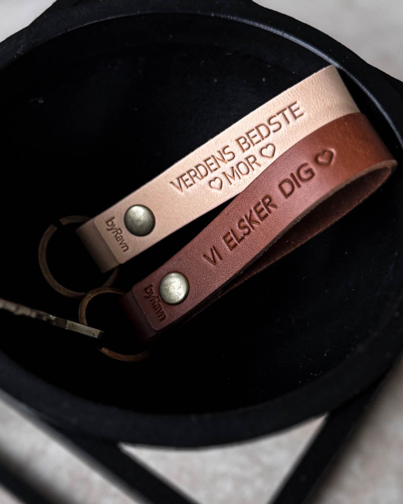 RAVN leather keyrings in natural and cognac in a black bowl with personalised engraving "Verdens bedste mor" ♡ and "Vi elsker dig" ♡