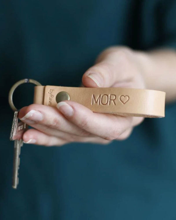 RAVN leather keyring in natural with the engraving "Mor" ♡, held in hand with keys