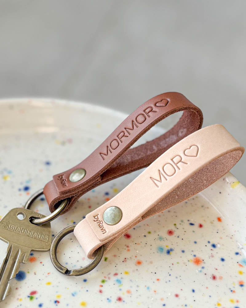 RAVN leather keyrings in natural and cognac in a dotted ceramic bowl with the engravings "Mor" ♡ and "Mormor" ♡ plus key