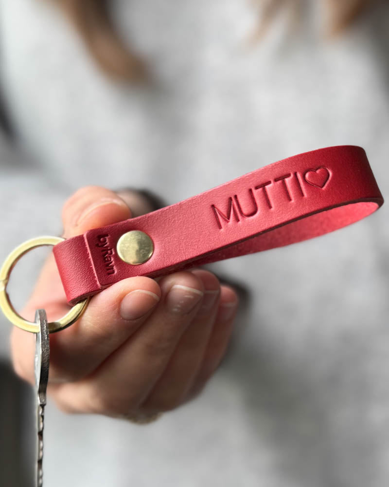 RAVN leather keyring in red with personalised engraving "Mutti" ♡ and brass rivet, held in hand with key