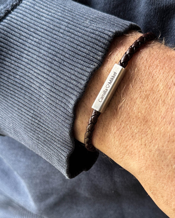 RIO leather bracelet in dark brown braided leather with "Camilla ♡ Mikkel" engraved on the steel clasp, worn on the wrist