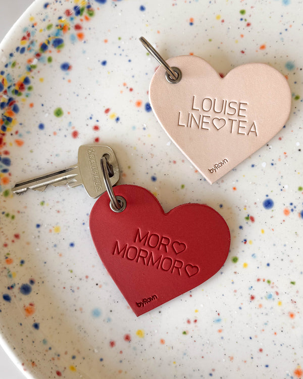 ROSE heart keyrings in natural and red leather with the engravings "Louise Line ♡ Tea" and "Mor ♡ Mormor ♡" on a dotted plate