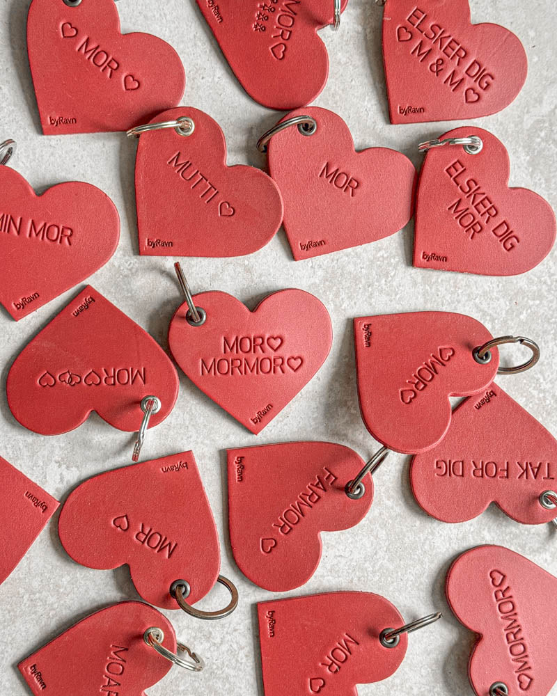 Red ROSE leather heart keyrings seen from above with engravings such as "Elsker dig ♡ M & M ♡", "Min mor" and "Farmor" ♡