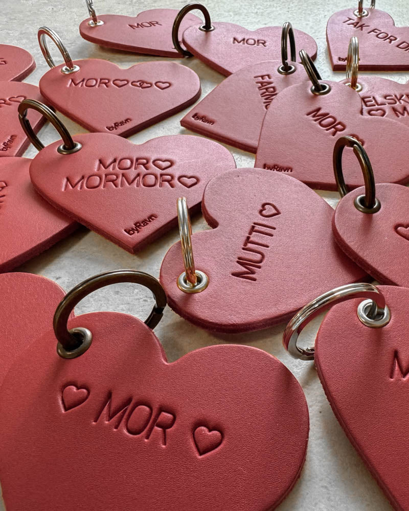 Close-up of red ROSE leather heart keyrings with the engravings ♡ "Mor" ♡, "Mutti" ♡ and "Mor ♡ Mormor ♡"