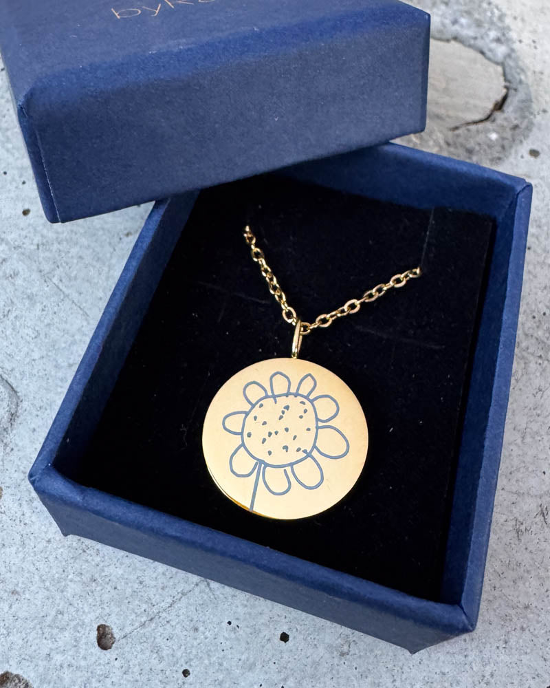 SIA MOTIF necklace in gold-plated stainless steel engraved with a child's drawing of a flower, in a navy blue byRavn gift box