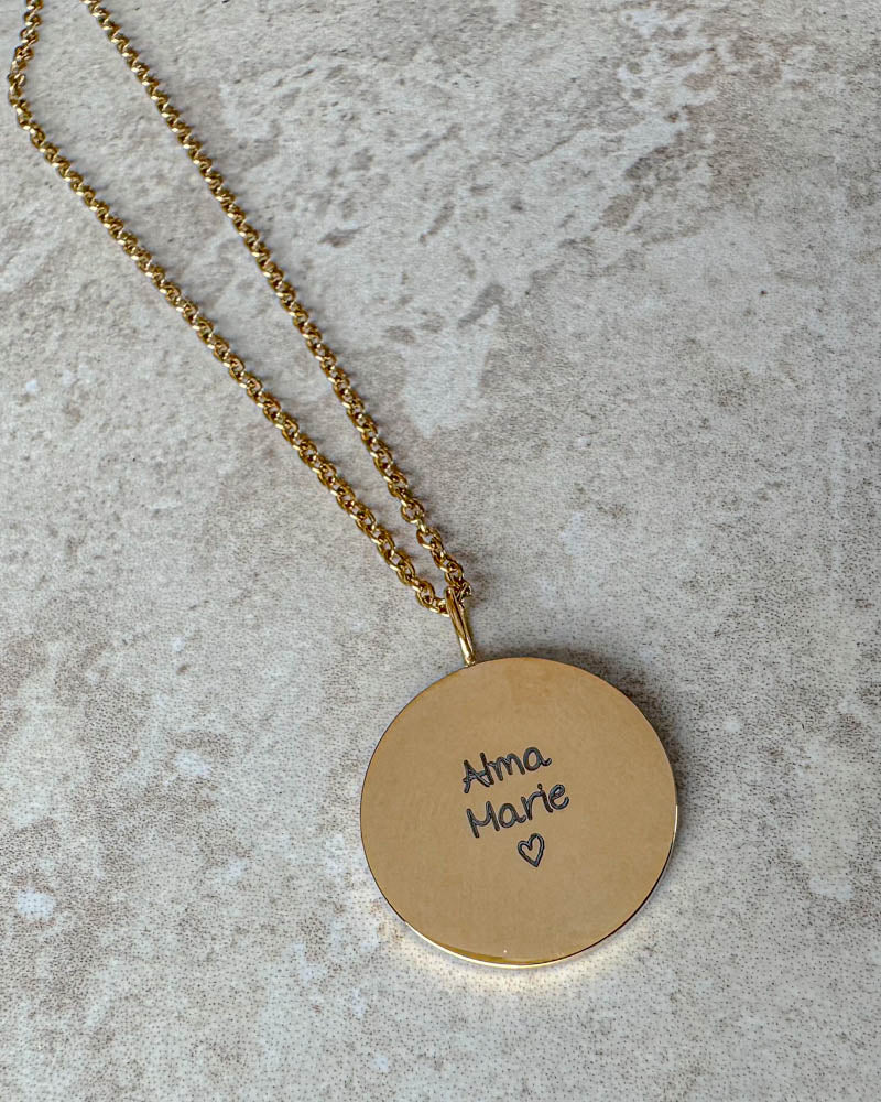SIA QUOTE SCRIPT name necklace in gold-plated steel with "Alma Marie" ♡ in handwriting engraved on a round pendant, on light stone