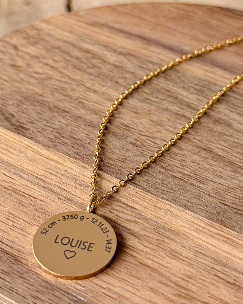 SIA MOMENTS necklace in gold-plated steel with "Louise" ♡ and birth data "52 cm - 3750 g - 12.11.23 - 14.37" engraved, on a wooden dish