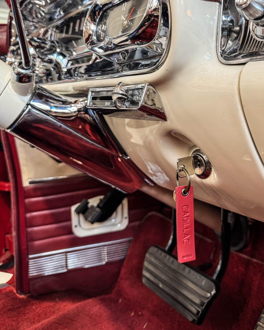 SOLO Small keyring in red leather with the engraving "Cadillac" hanging from the ignition of a classic car