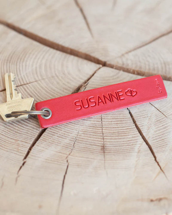 SOLO Medium keyring in red leather with the name "Susanne" and two hearts engraved, with key on a wooden slice
