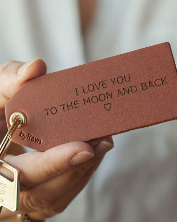 STORM keyring in cognac leather held in hand with key and the engraving "I love you to the moon and back" ♡
