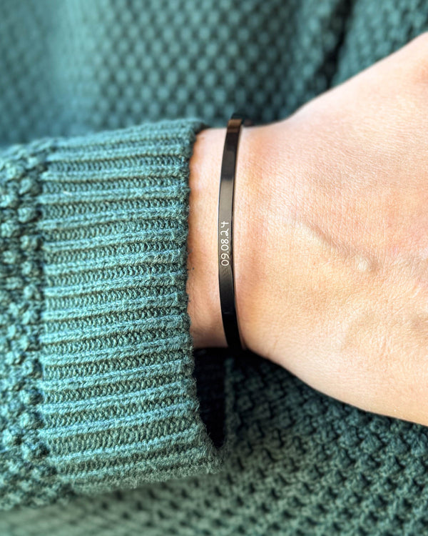 VENUS SCRIPT bracelet in black stainless steel with the date "09.08.24" in script on the wrist, green knit