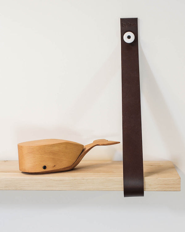 WAVE leather strap in dark brown with porcelain knob holds a wooden shelf with a wooden whale