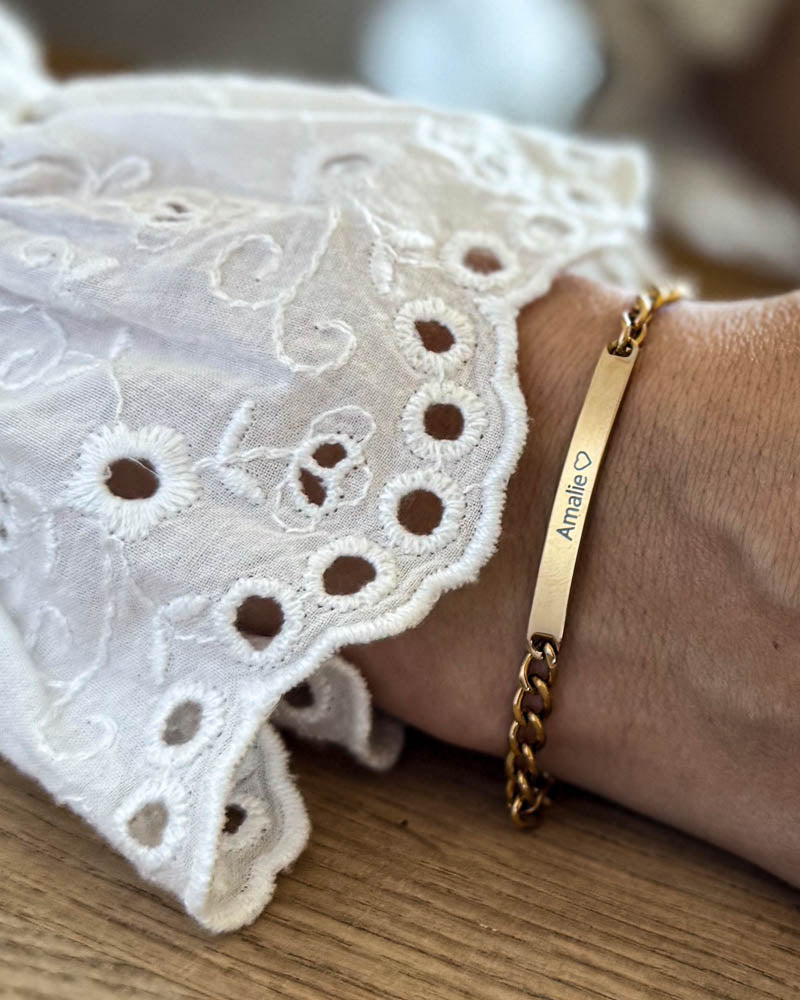 ZOE name bracelet in gold-plated stainless steel with the name "Amalie" ♡ engraved, worn on the wrist with a white lace blouse
